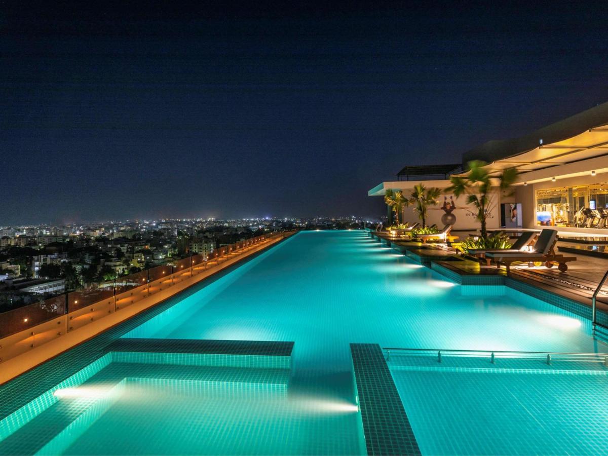 a swimming pool on the roof of a building at night at Novotel Vijayawada Varun in Vijayawāda
