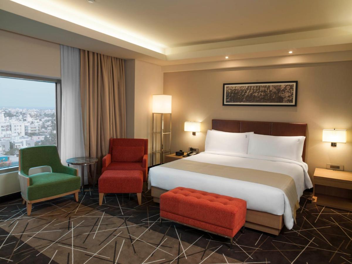 a hotel room with a bed and two chairs at Holiday Inn Chennai OMR IT Expressway by IHG in Chennai