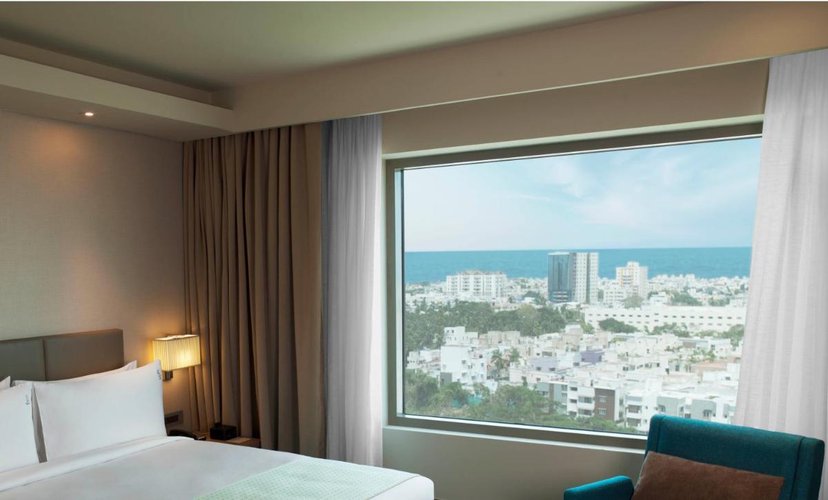 a hotel room with a bed and a large window at Holiday Inn Chennai OMR IT Expressway by IHG in Chennai