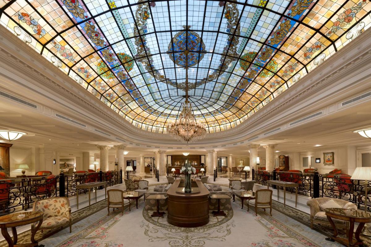 Un gran vestíbulo con un gran techo de vidrieras. en Eurostars Palacio Buenavista, en Toledo