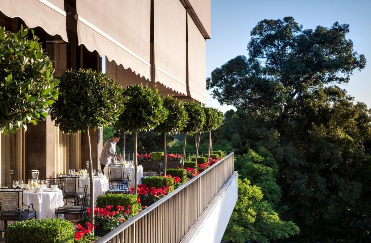 um restaurante com mesas e flores ao lado de um edifício em Four Seasons Hotel Ritz Lisbon em Lisboa