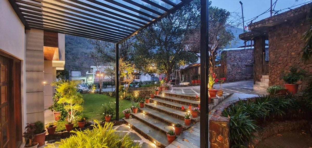 a patio with a bunch of benches and lights at Antalya By Divine Ganga Cottage in Rishīkesh