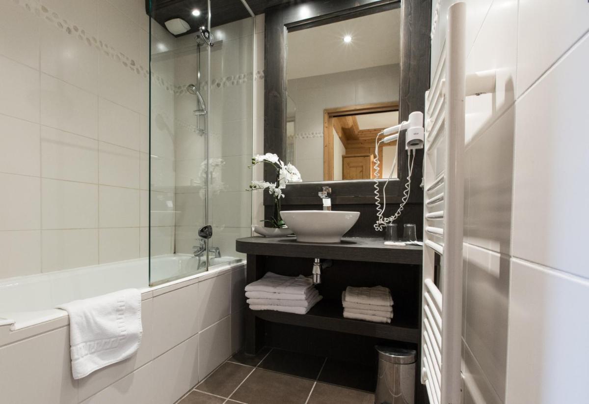 une salle de bain avec un lavabo et un miroir dans l'établissement Hotel Club Le Crêt, à Morzine