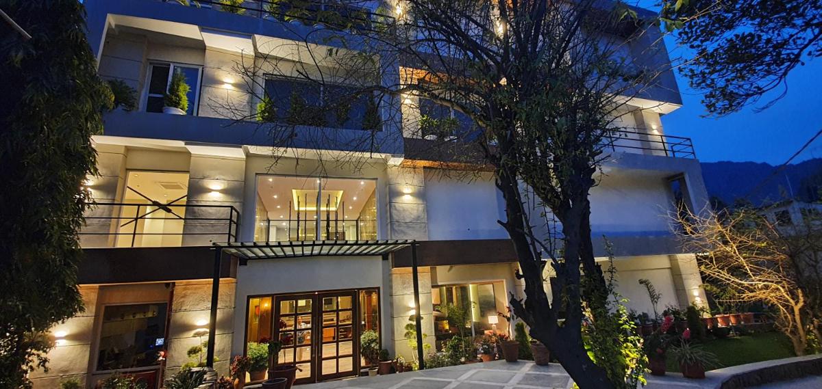 a large white building with lights on at Antalya By Divine Ganga Cottage in Rishīkesh