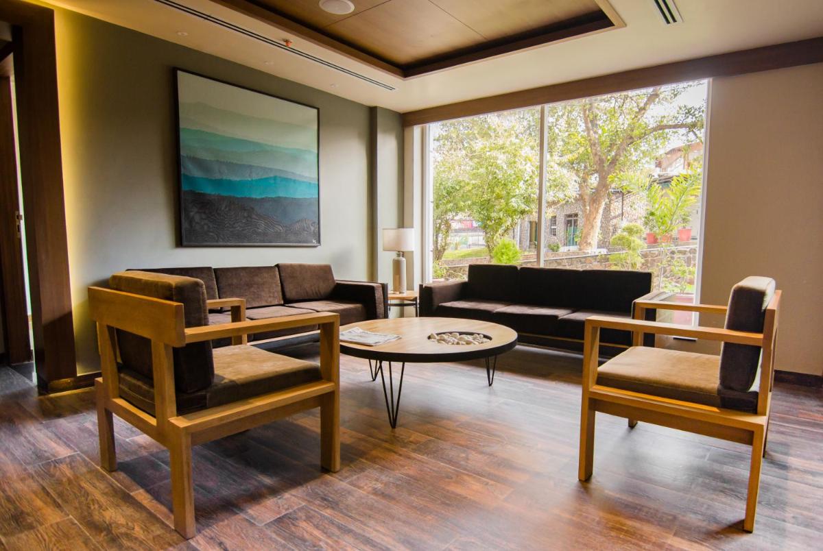 a living room with a couch and a table at Antalya By Divine Ganga Cottage in Rishīkesh