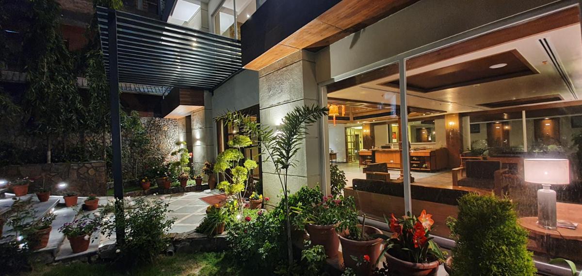 a lobby of a building with potted plants at Antalya By Divine Ganga Cottage in Rishīkesh