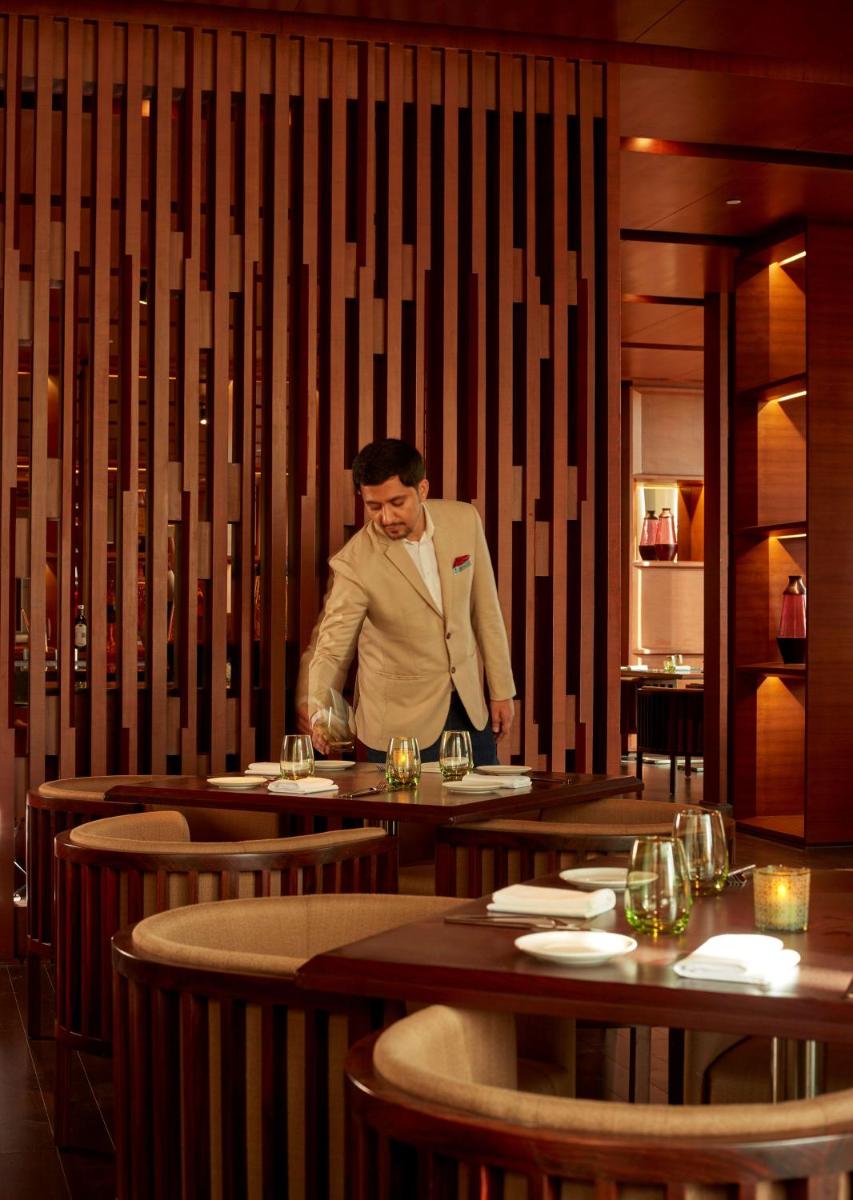 a man standing at a table in a restaurant at Hyatt Regency Chandigarh in Chandīgarh