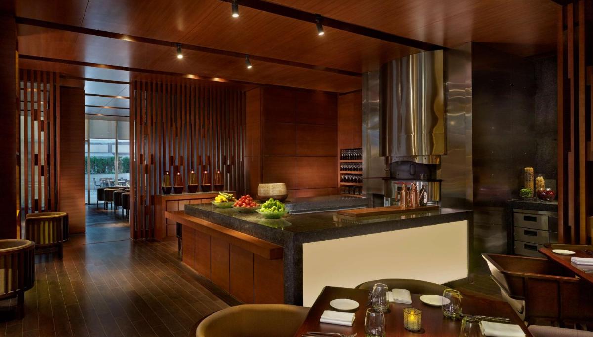 a kitchen with a counter and some tables and chairs at Hyatt Regency Chandigarh in Chandīgarh