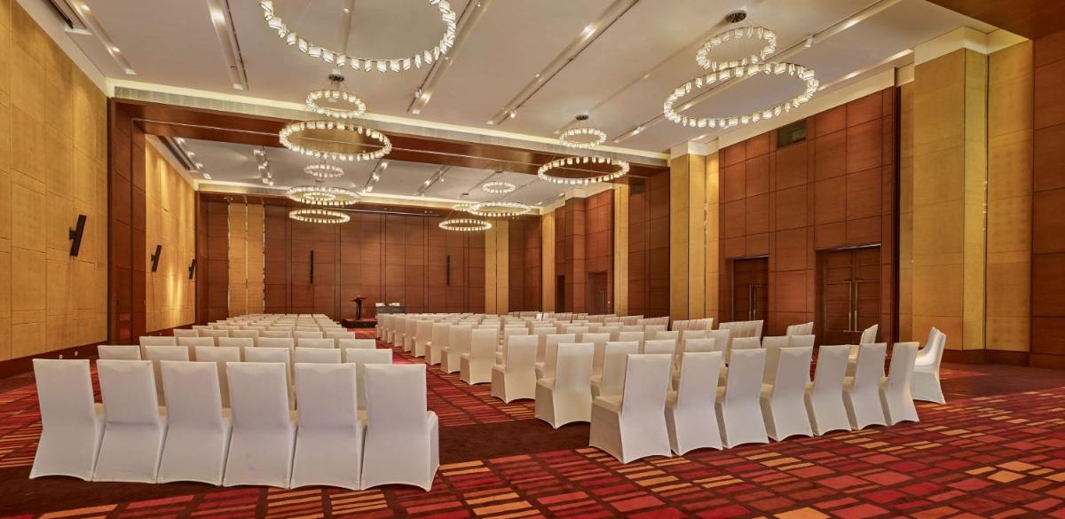 a room with rows of white chairs and chandeliers at Hyatt Regency Chandigarh in Chandīgarh
