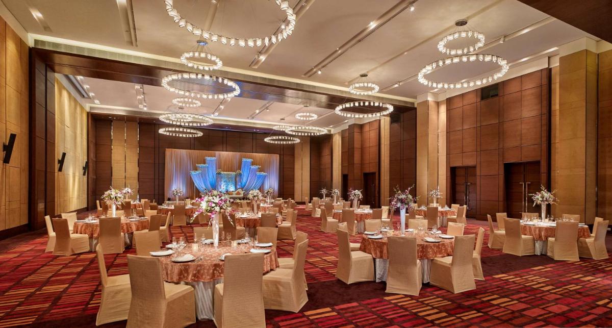 a large room with tables and chairs and chandeliers at Hyatt Regency Chandigarh in Chandīgarh