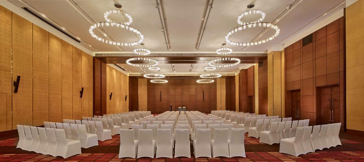 a large room with rows of white chairs and chandeliers at Hyatt Regency Chandigarh in Chandīgarh