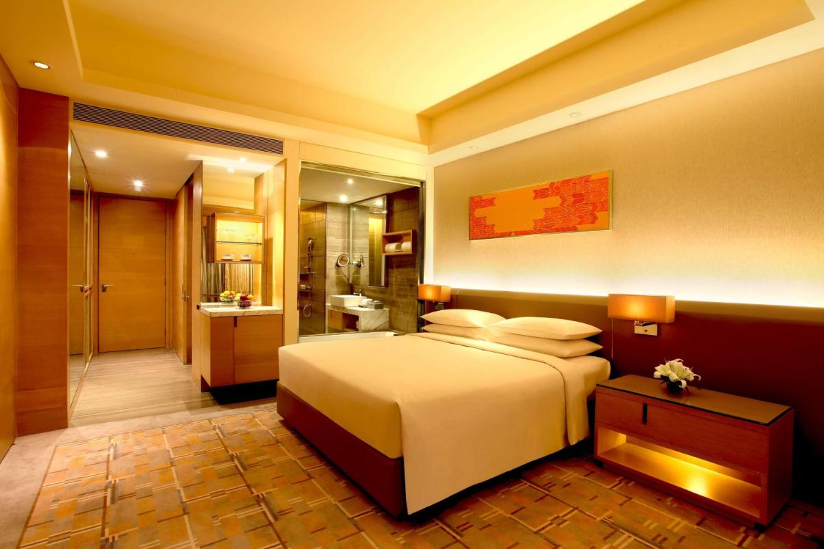 a bedroom with a large bed and a bathroom at Hyatt Regency Chandigarh in Chandīgarh