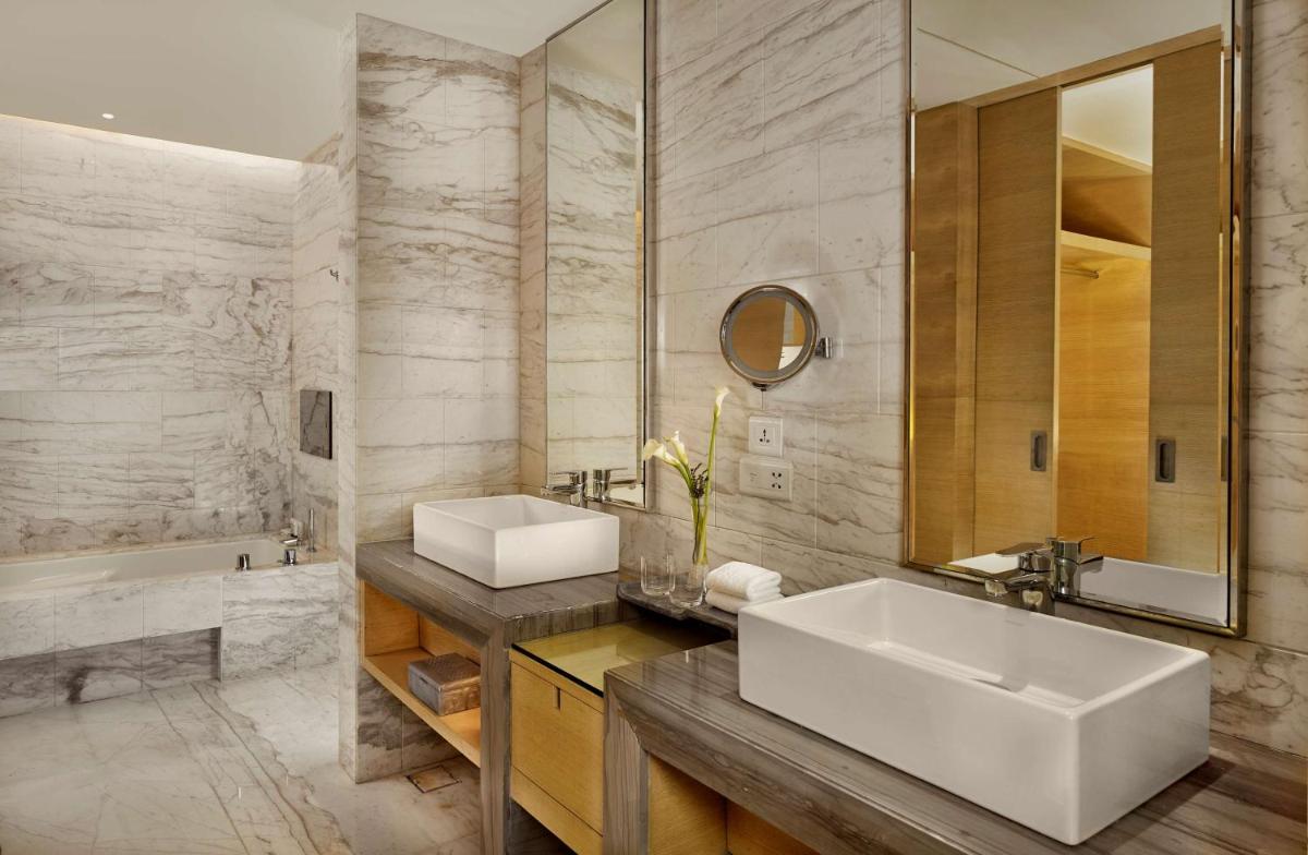 a bathroom with a sink and a mirror and a tub at Hyatt Regency Chandigarh in Chandīgarh