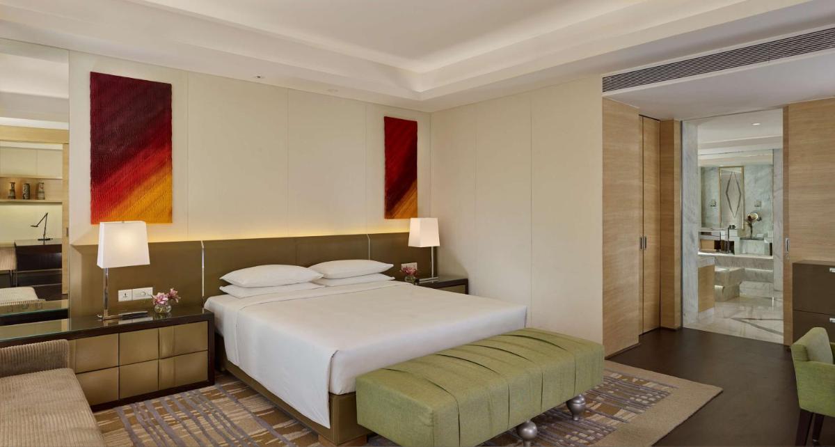 a bedroom with a large bed and a bathroom at Hyatt Regency Chandigarh in Chandīgarh