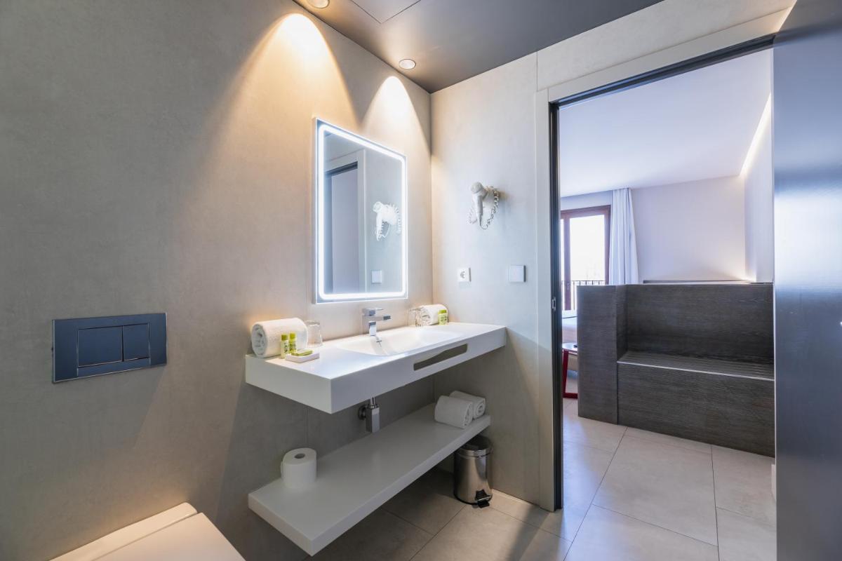 un baño con lavabo y espejo en MYR Plaza Mercado & Spa, en Valencia 84 fotos más