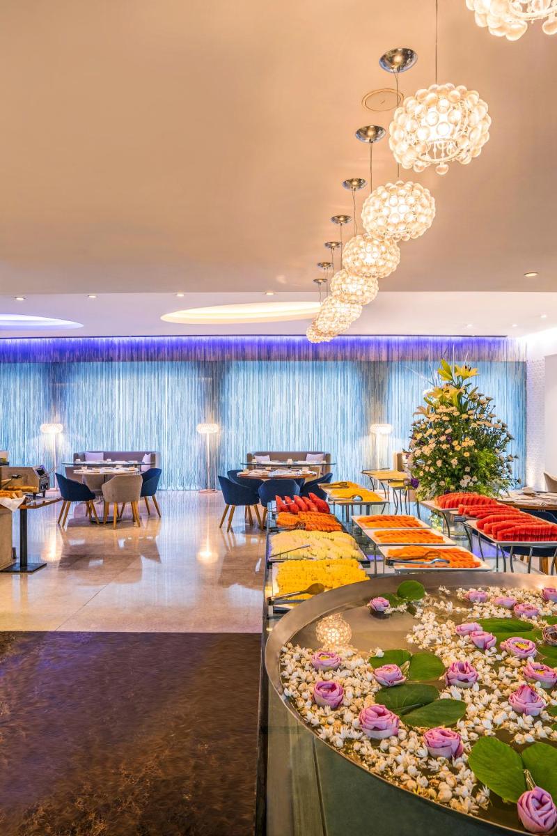 a hotel lobby with tables and chairs and chandeliers at The Park New Delhi in New Delhi a hotel lobby with tables and chairs and chandeliers at The Park New Delhi in New Delhi