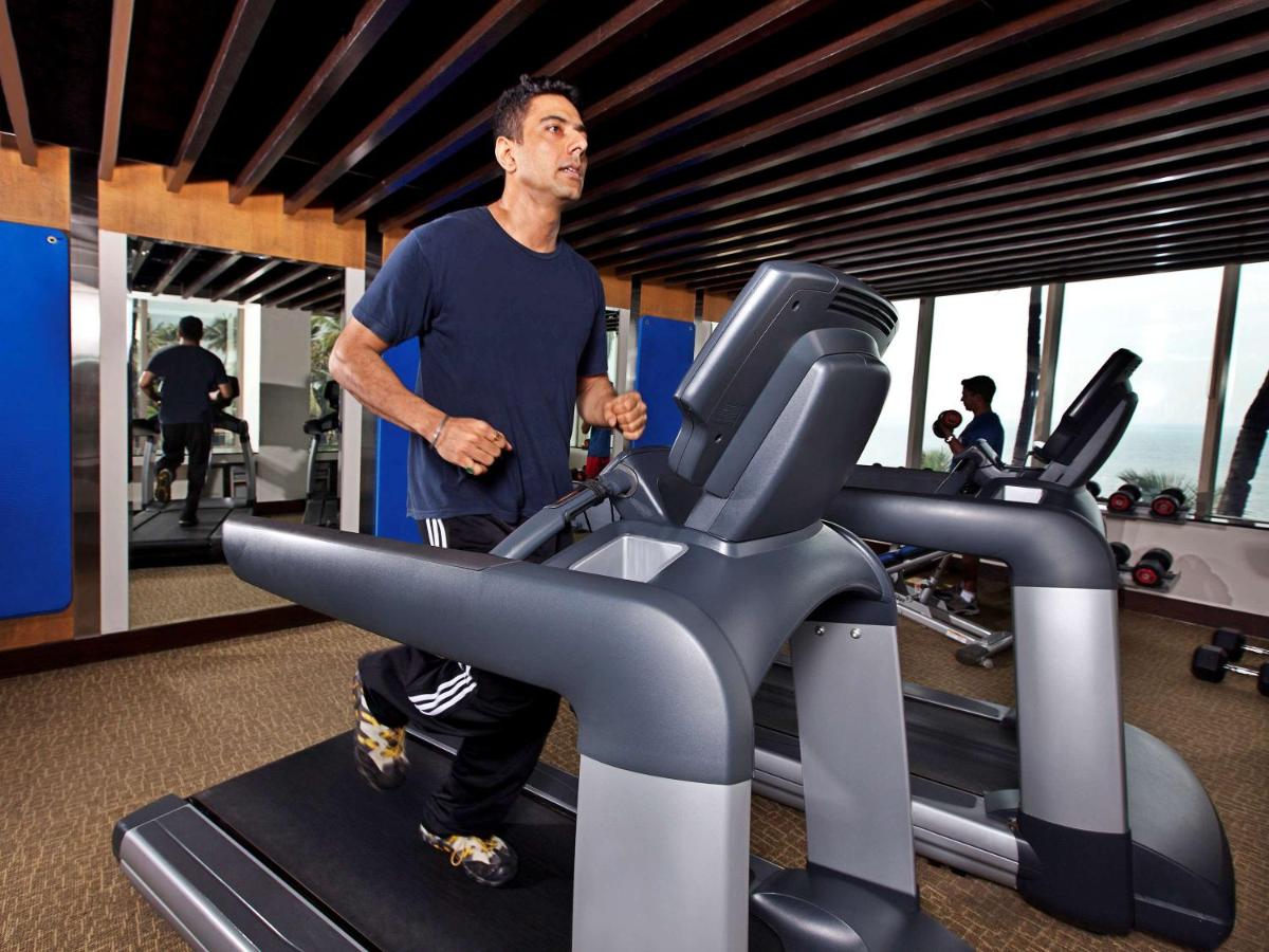 a man running on a treadmill in a gym at Novotel Mumbai Juhu Beach in Mumbai