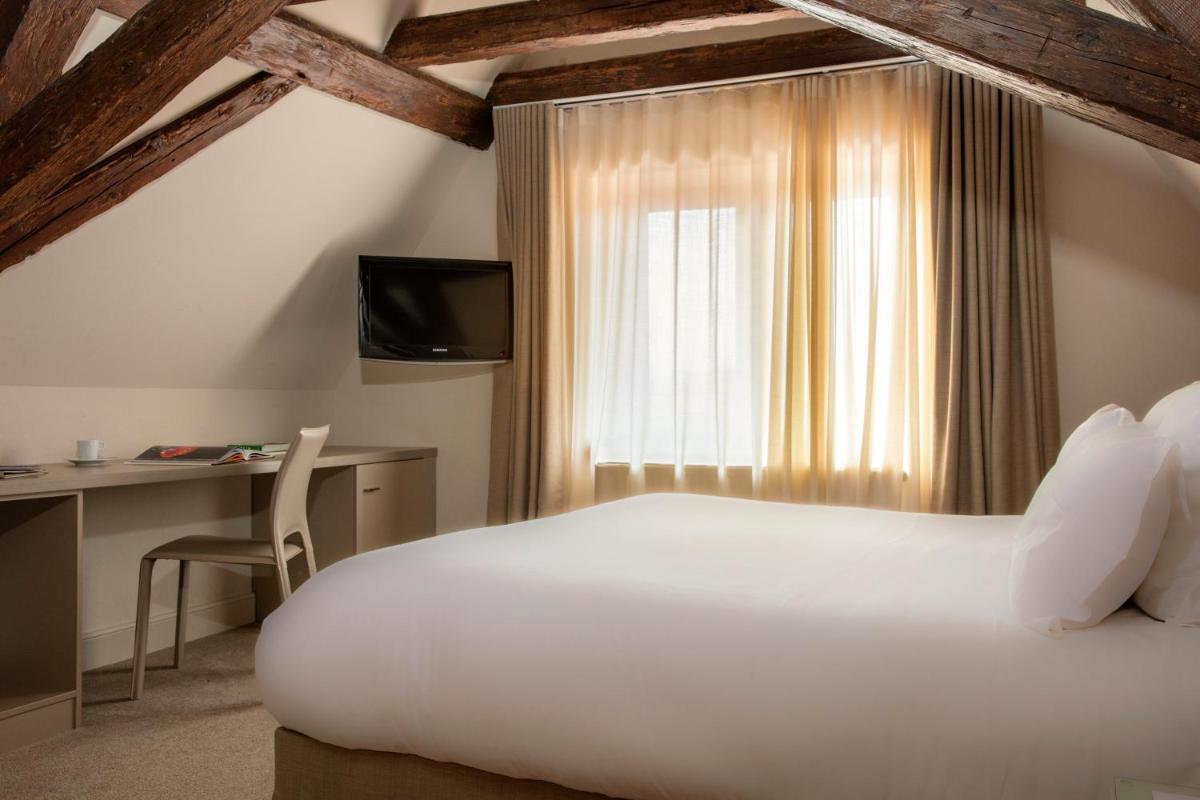 Un ou plusieurs lits dans un hébergement de l'établissement Relais & Châteaux La Maison Des Têtes
