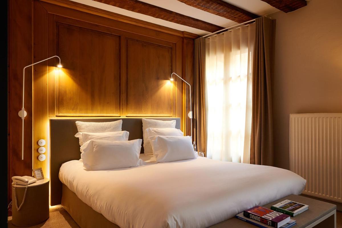 Un ou plusieurs lits dans un hébergement de l'établissement Relais & Châteaux La Maison Des Têtes