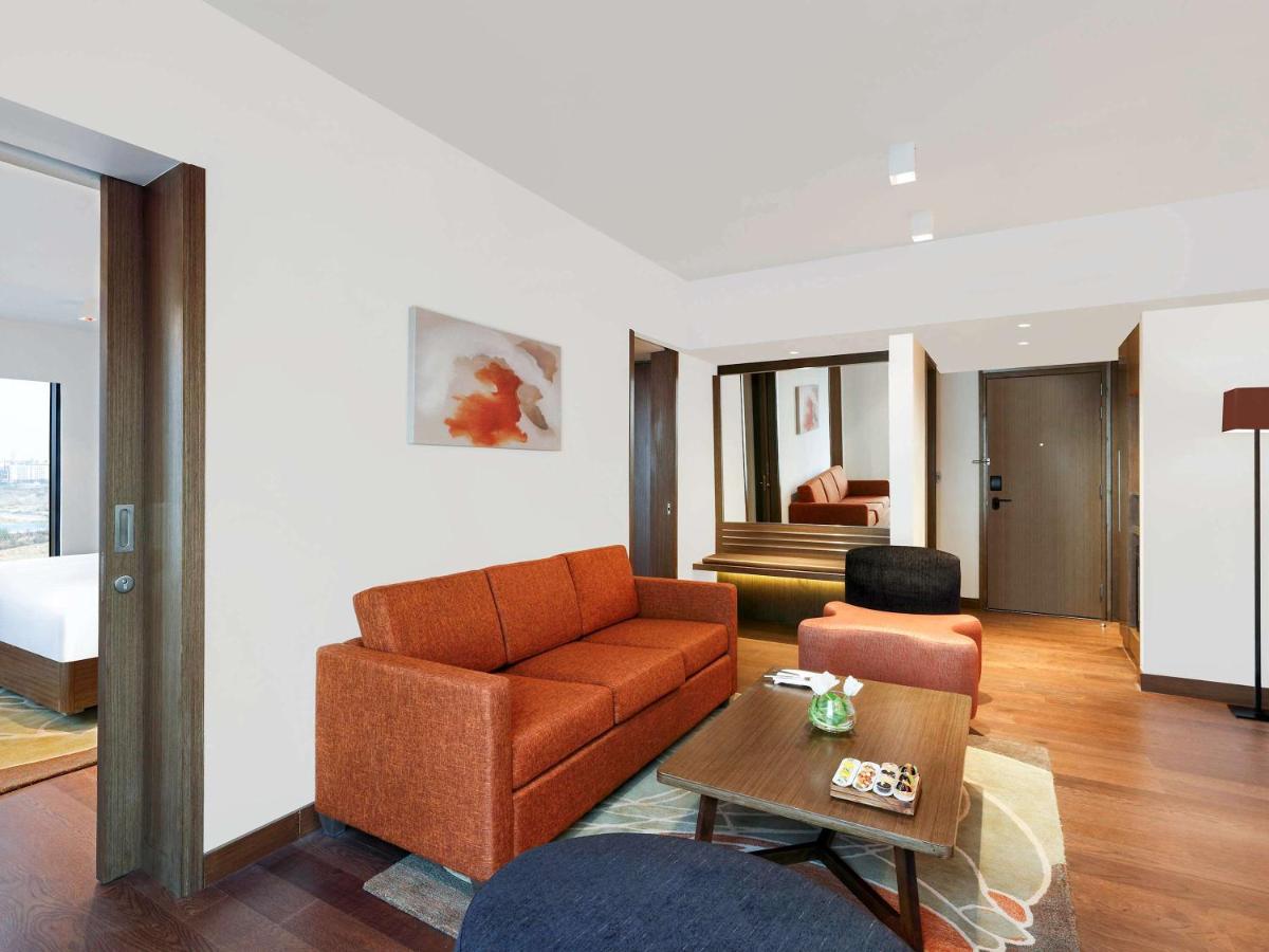 a living room with a couch and a table at Novotel New Delhi Aerocity in New Delhi
