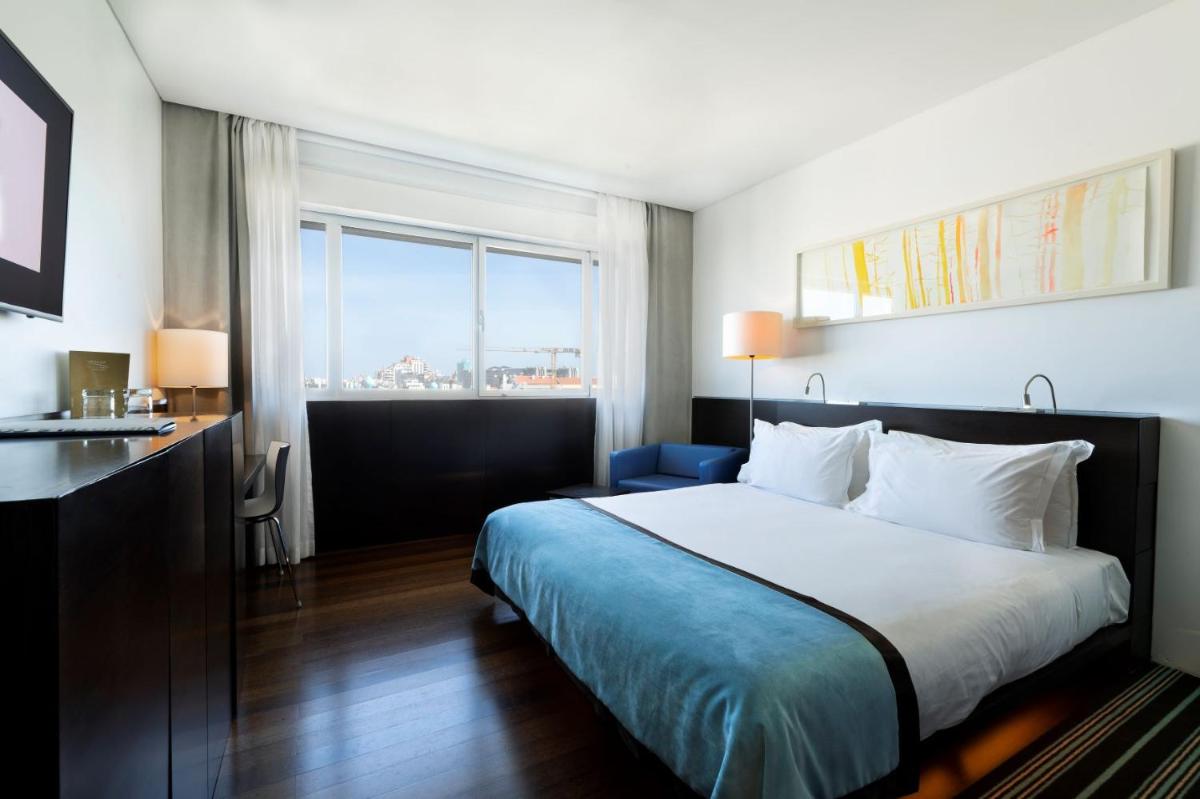 um quarto de hotel com uma cama e uma janela em VIP Grand Lisboa Hotel & Spa em Lisboa