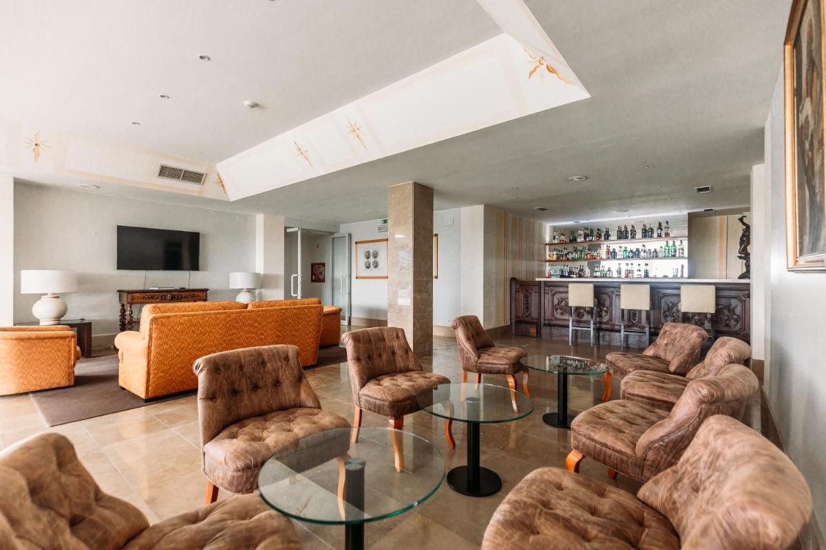 uma sala de estar com sofás, uma mesa e cadeiras em Conimbriga Hotel do Paço em Condeixa a Nova