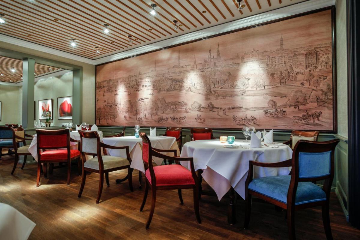 ein Restaurant mit Tischen und Stühlen und einer großen Wand in der Unterkunft Hotel Stadt Hamburg in Westerland