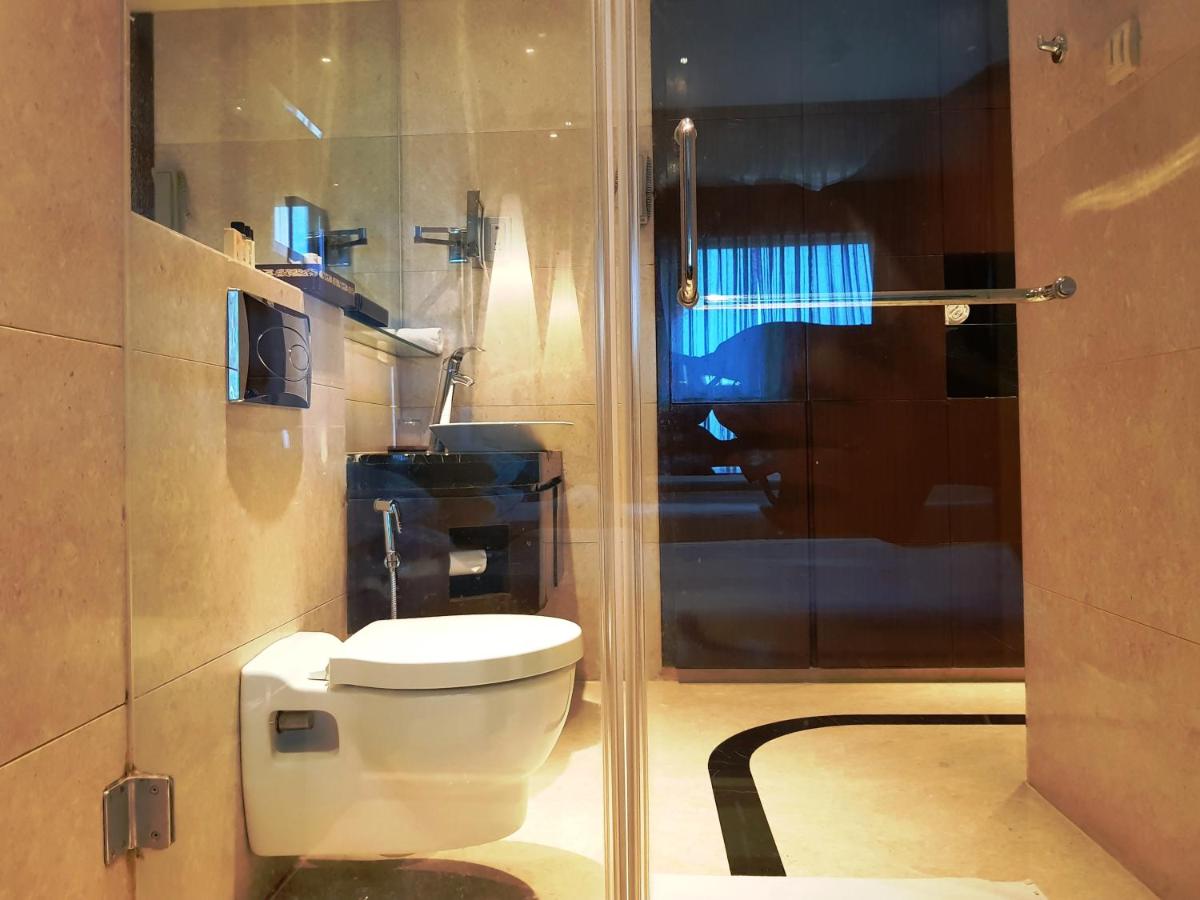 a bathroom with a toilet and a glass shower at Vivanta Hyderabad, Begumpet in Hyderabad a bathroom with a toilet and a glass shower at Vivanta Hyderabad, Begumpet in Hyderabad