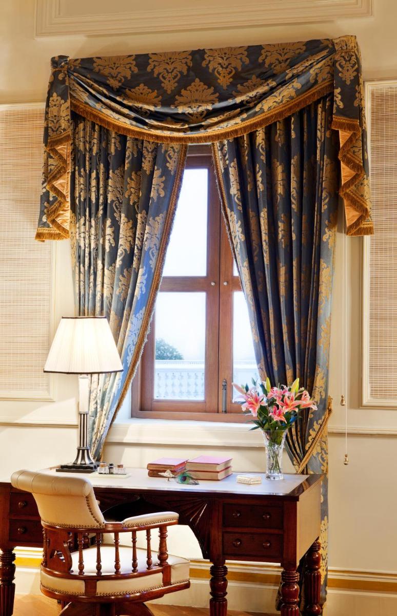 a window with a desk with a vase of flowers at Taj Falaknuma Palace in Hyderabad