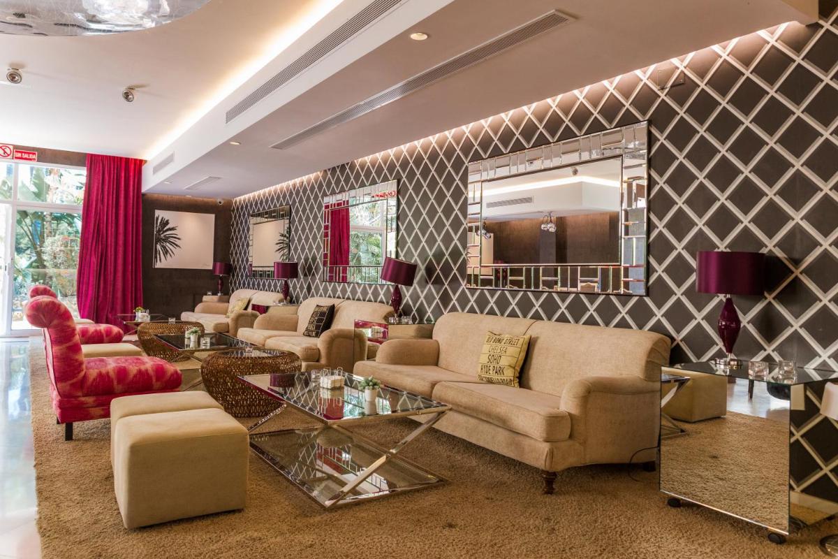 sala de estar con muebles y espejo. en Aparthotel Monarque Sultán, en Marbella