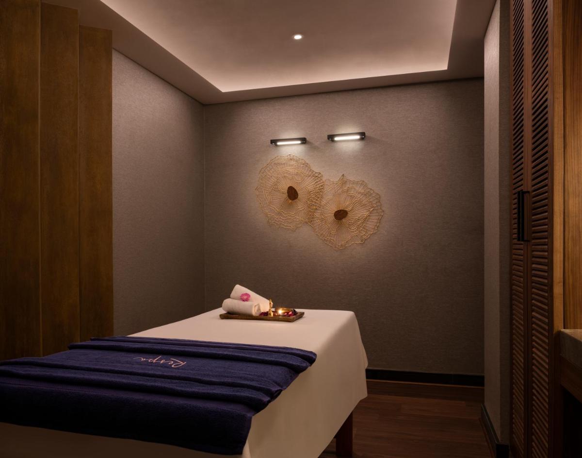 a room with a bed and two masks on the wall at The Residency Towers Puducherry in Puducherry