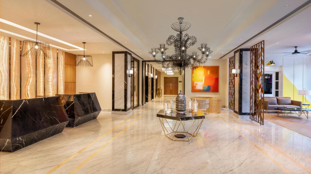 a lobby with a chandelier and a living room at The Residency Towers Puducherry in Puducherry