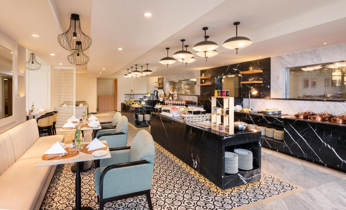 a restaurant with tables and chairs and a counter at The Residency Towers Puducherry in Puducherry