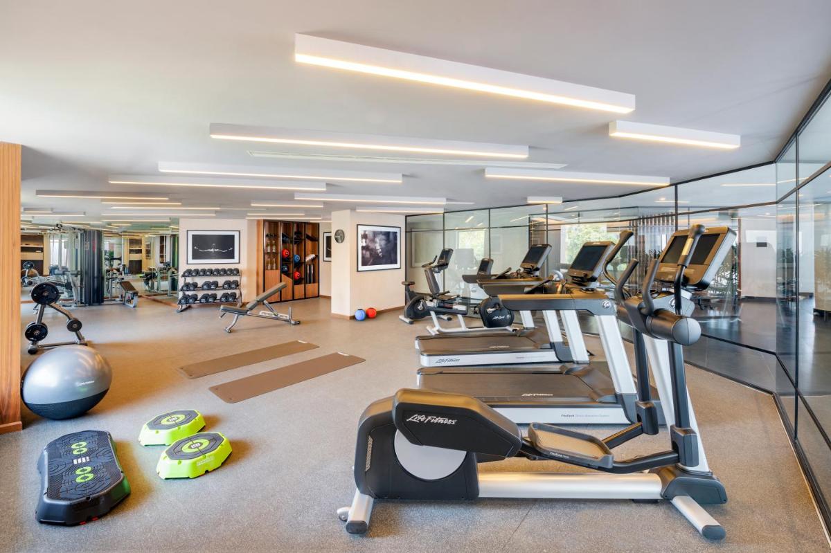 a gym with a bunch of treadms and ellipticals at The Residency Towers Puducherry in Puducherry