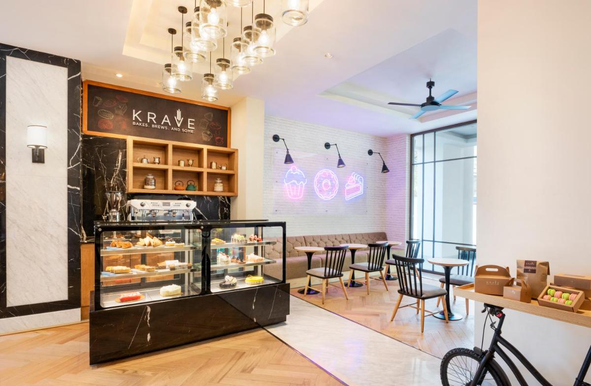 a restaurant with a bakery with tables and chairs at The Residency Towers Puducherry in Puducherry