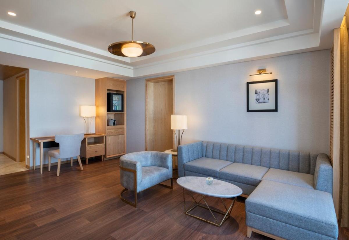 a living room with a couch and a table and chairs at The Residency Towers Puducherry in Puducherry
