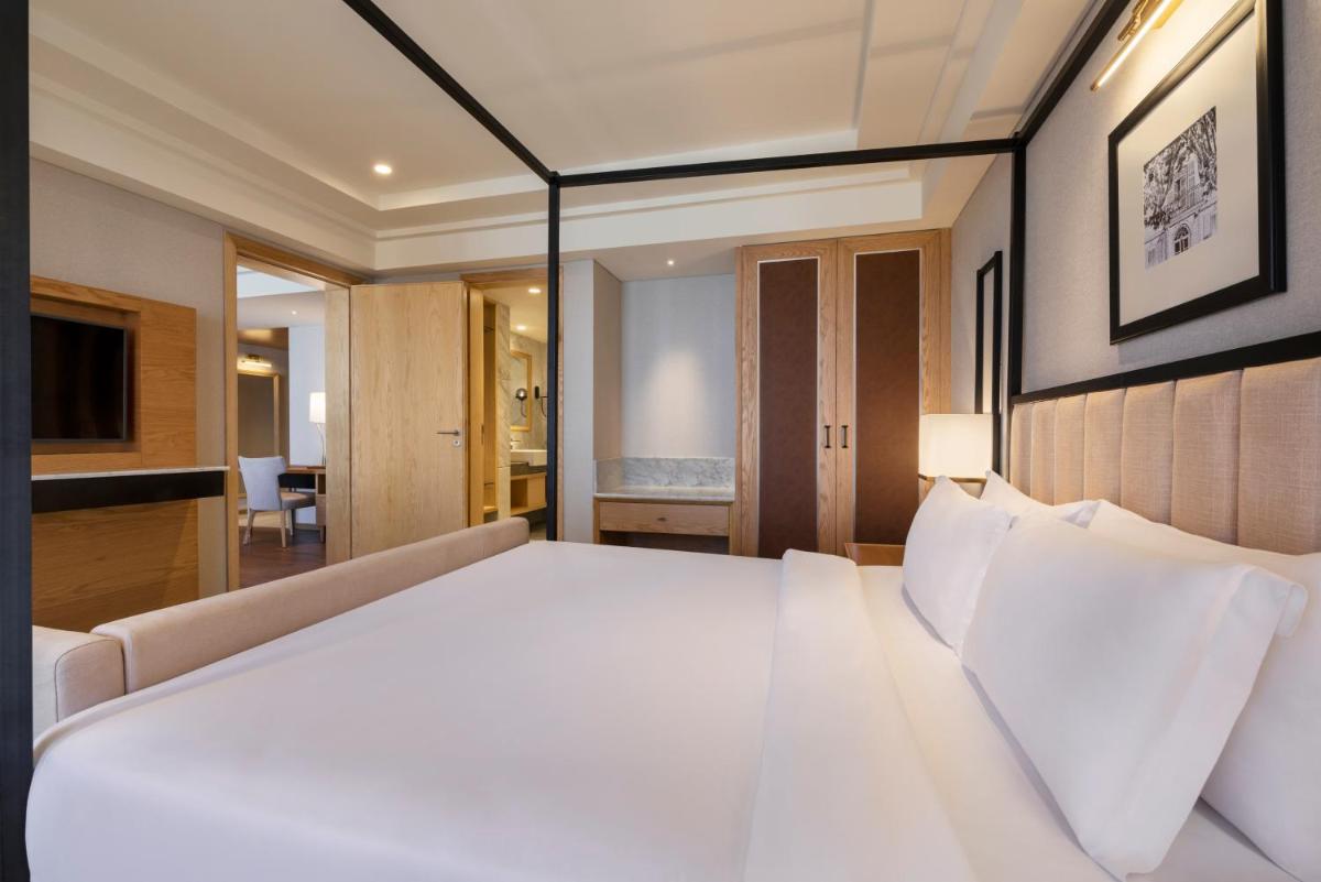 a bedroom with a large white bed and a couch at The Residency Towers Puducherry in Puducherry