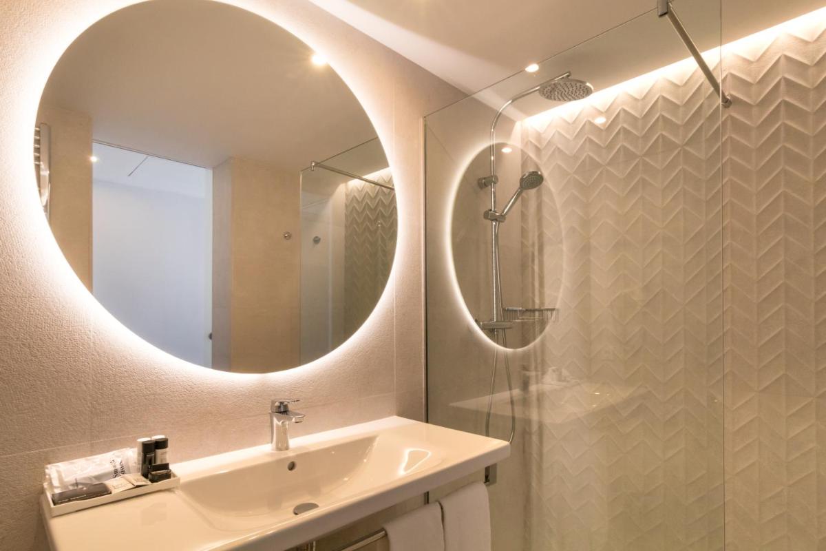 un baño con lavabo y espejo en Hotel Cap Negret, en Altea 51 fotos más