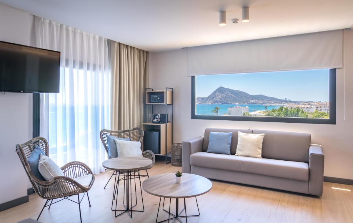 Una sala de estar con un sofá y un televisor. en Hotel Cap Negret, en Altea