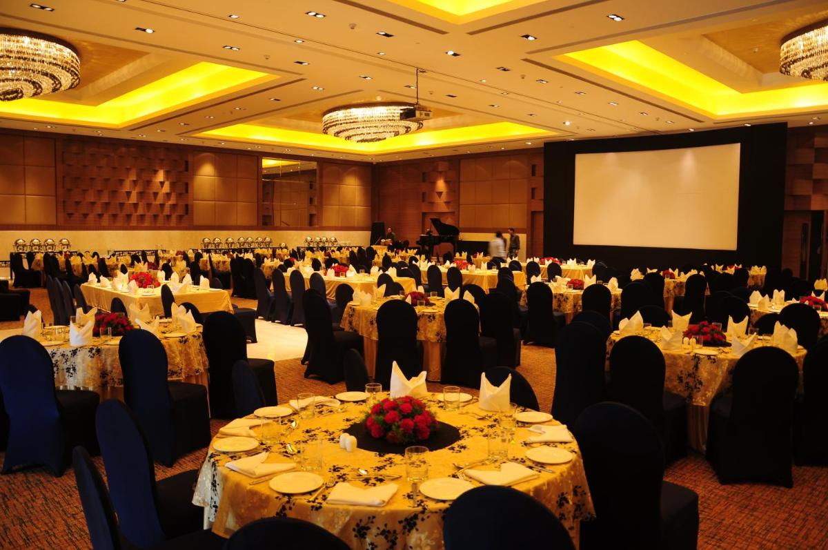 a banquet hall with tables and chairs and a screen at The Lalit Chandigarh in Chandīgarh