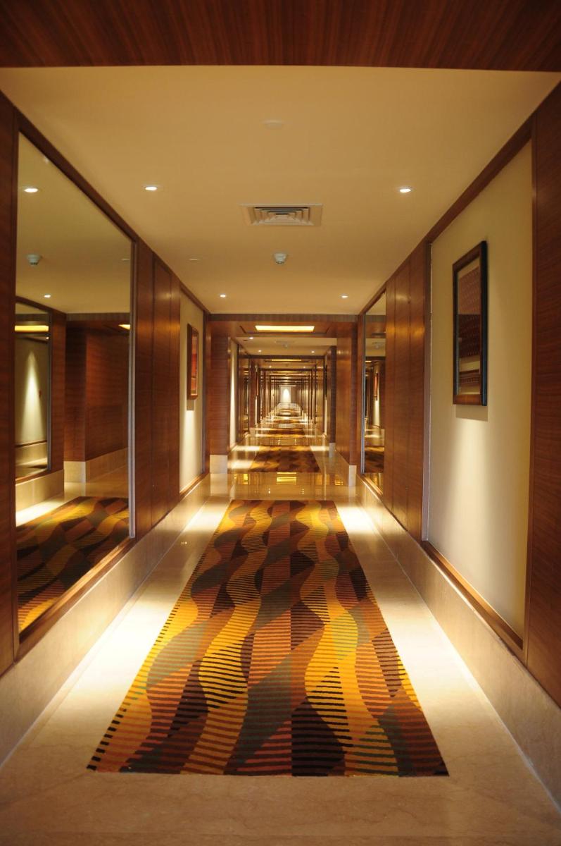 a hallway of a hotel with a rug on the floor at The Lalit Chandigarh in Chandīgarh