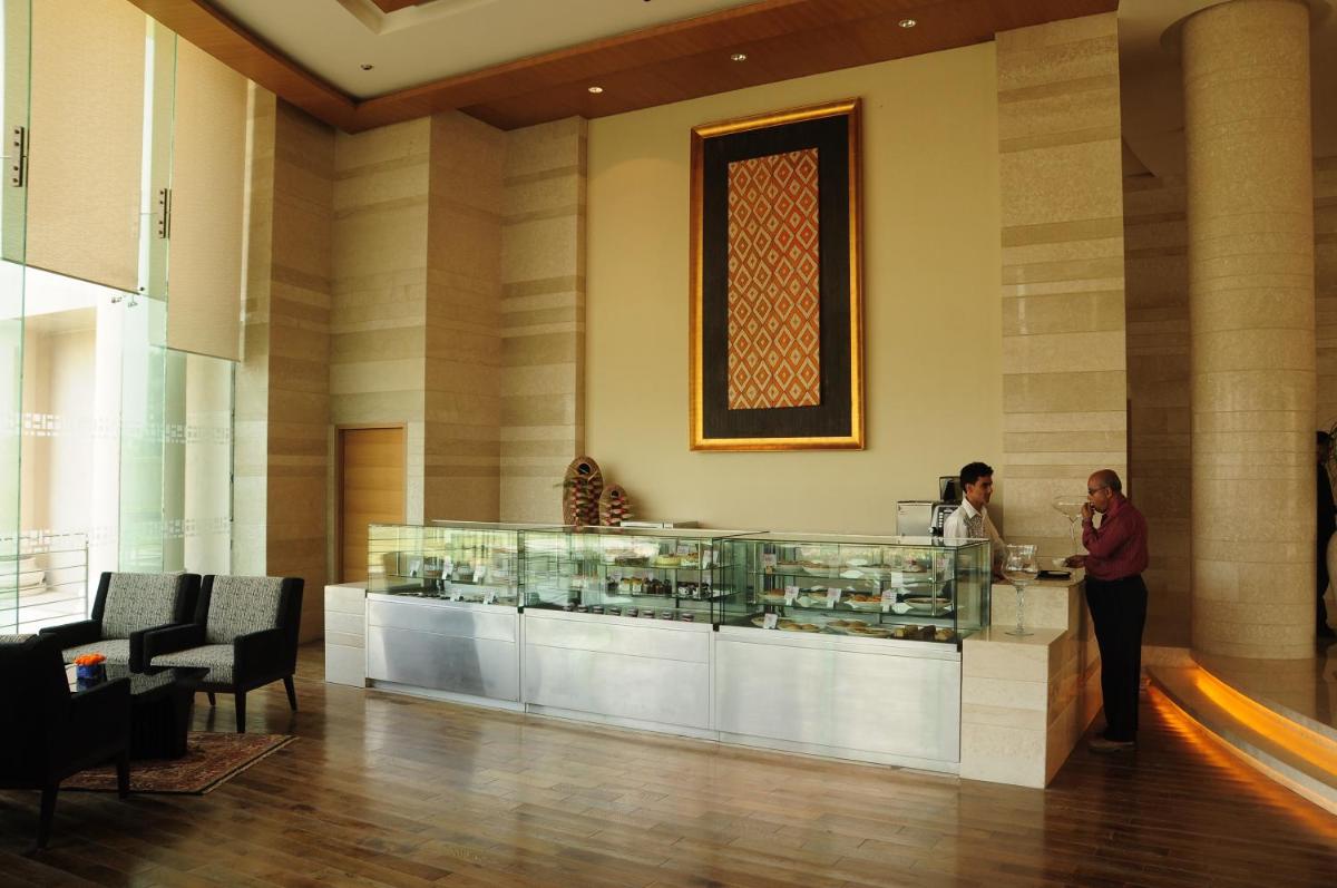 two people standing at a counter in a lobby at The Lalit Chandigarh in Chandīgarh