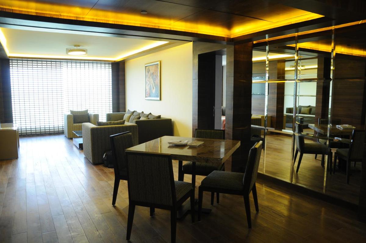 a dining room with a table and chairs at The Lalit Chandigarh in Chandīgarh