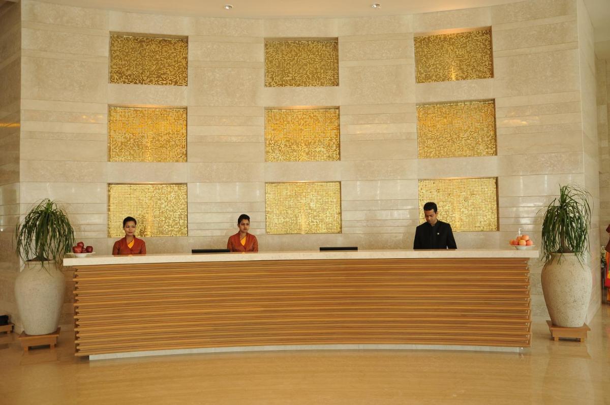 three men sitting at a counter in a lobby at The Lalit Chandigarh in Chandīgarh