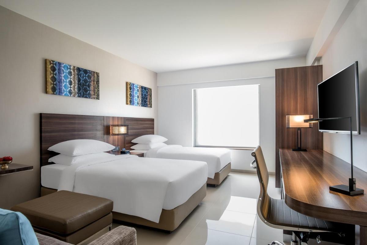a hotel room with two beds and a television at The Residency Towers, Rameswaram in Rāmeswaram