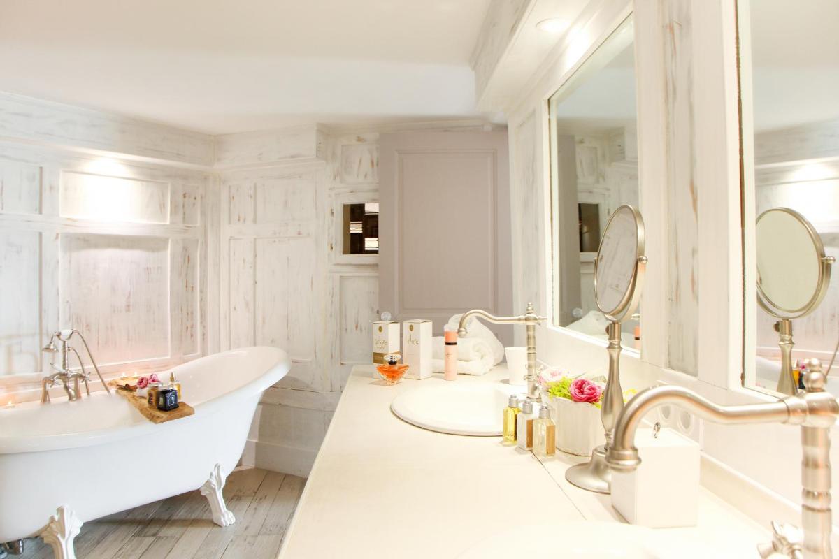 une salle de bain blanche avec une baignoire et un lavabo dans l'établissement L'Hostellerie du Moulin des Oliviers, à Olmeto