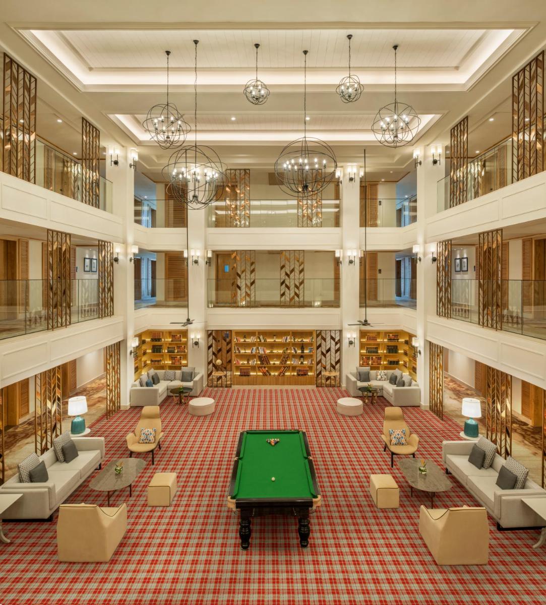 a large room with a green table in the middle at The Residency Towers Puducherry in Puducherry
