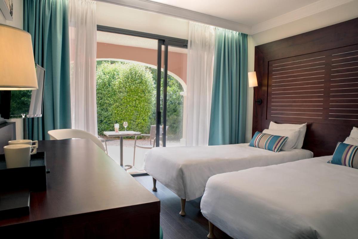 Un ou plusieurs lits dans un hébergement de l'établissement Hôtel Les Jardins De Sainte-Maxime