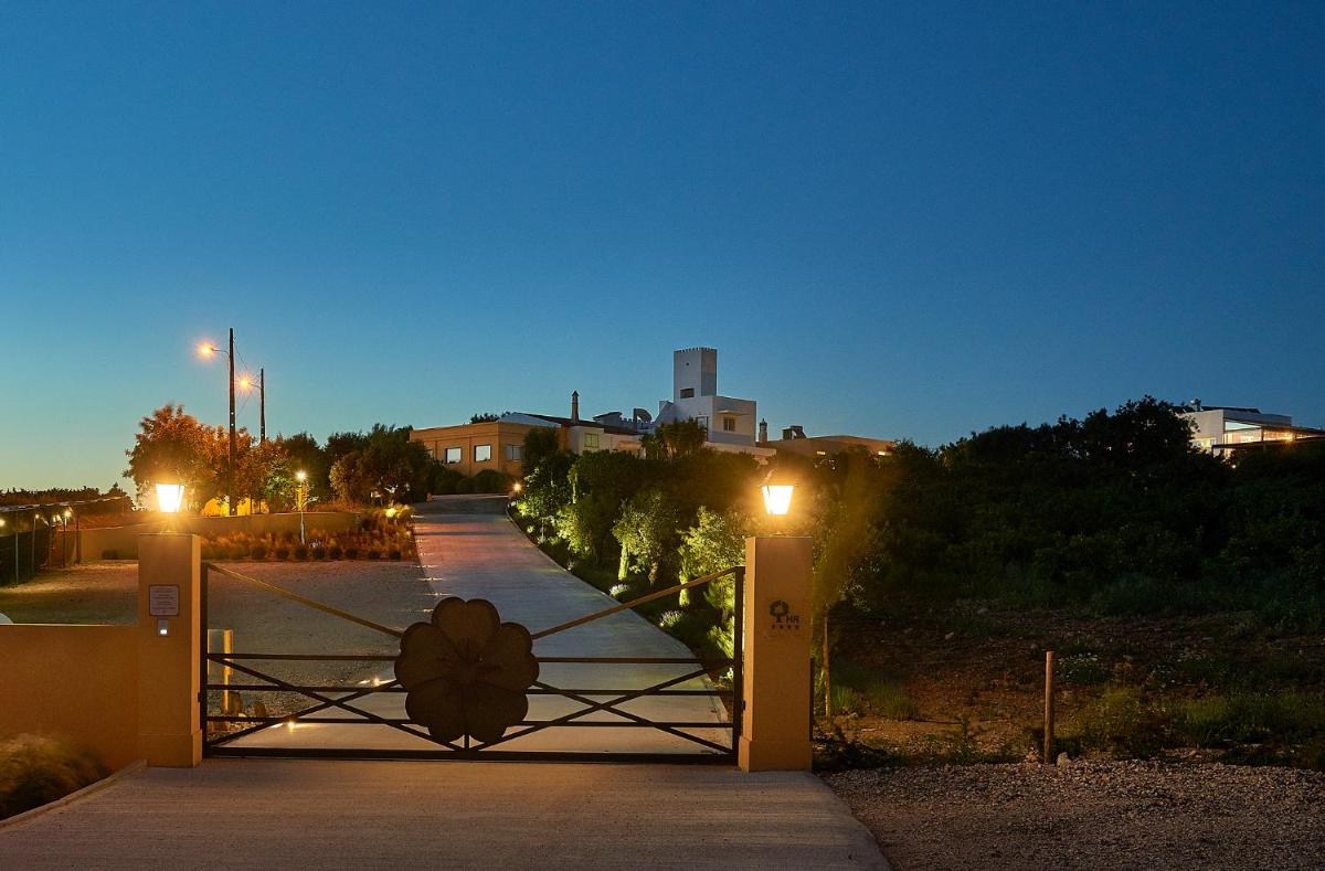 uma ponte sobre uma passarela com um portão à noite em Hotel Rural Quinta do Marco - Nature & Dining em Tavira