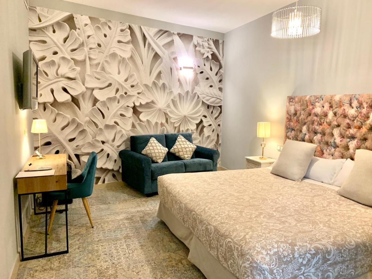 Un dormitorio con una cama, un sofá y un escritorio. en Akla Hotel Mérida, en Mérida